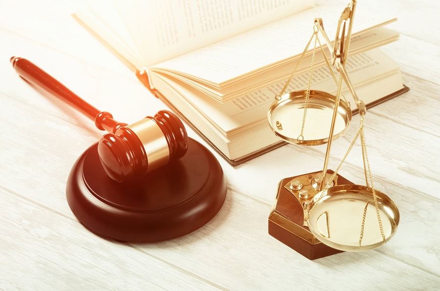 Balanced scale, legal books, and gavel on open law book representing legal services for bankruptcy and foreclosure in Long Island.