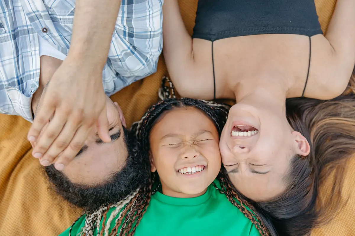 Family laughing together on a picnic blanket