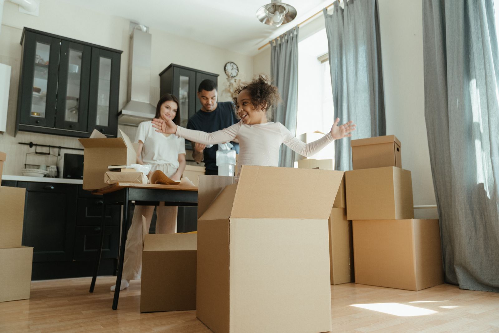 A joyful family unpacking moving boxes together as they settle into their home