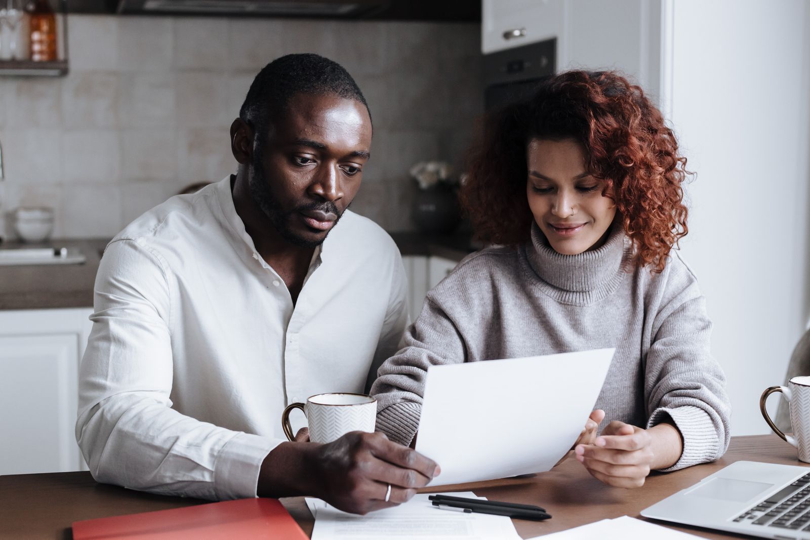 Couple reviewing paperwork together at their kitchen table