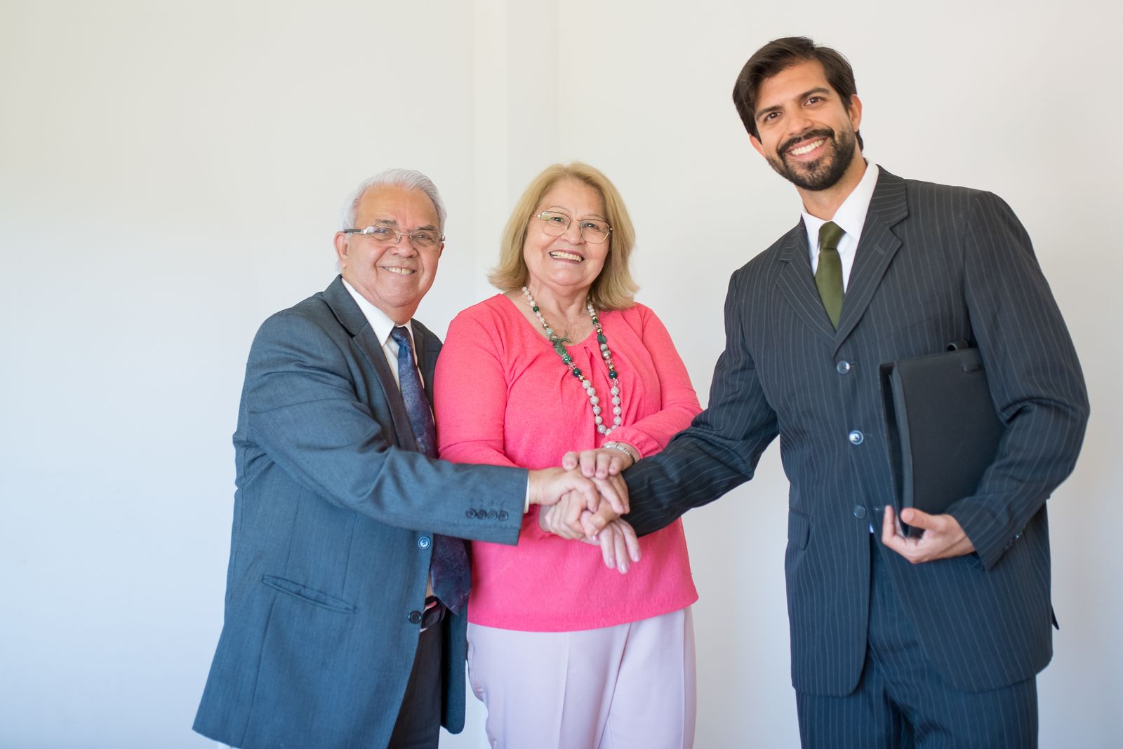 Mature couple shaking hands with their attorney after reaching agreement