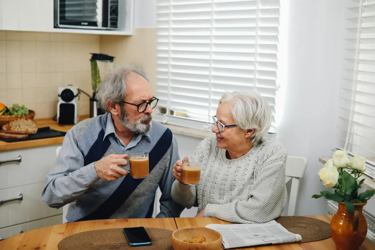 An older couple sharing coffee at their kitchen table