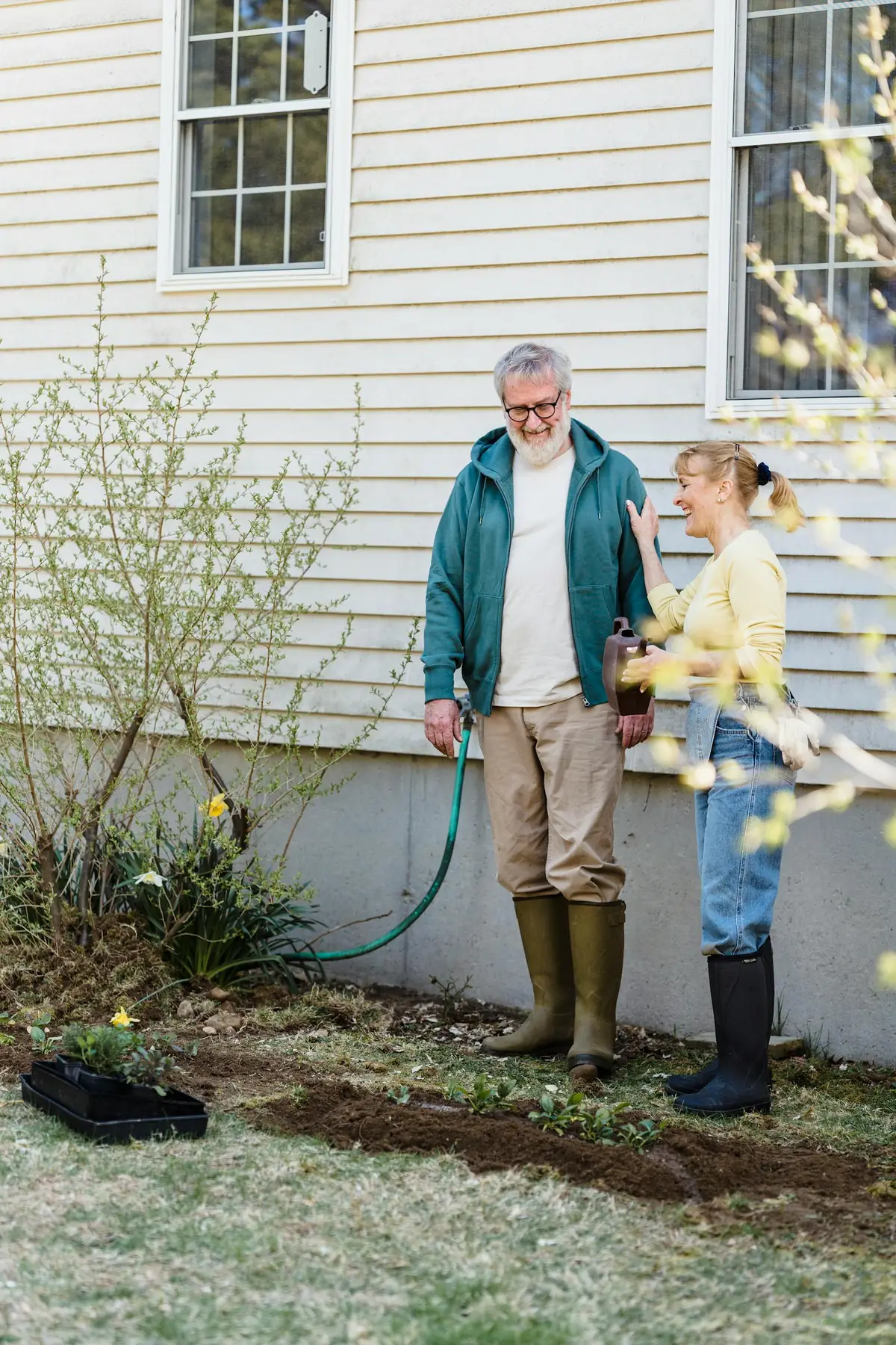 An older couple gardening together in their backyard