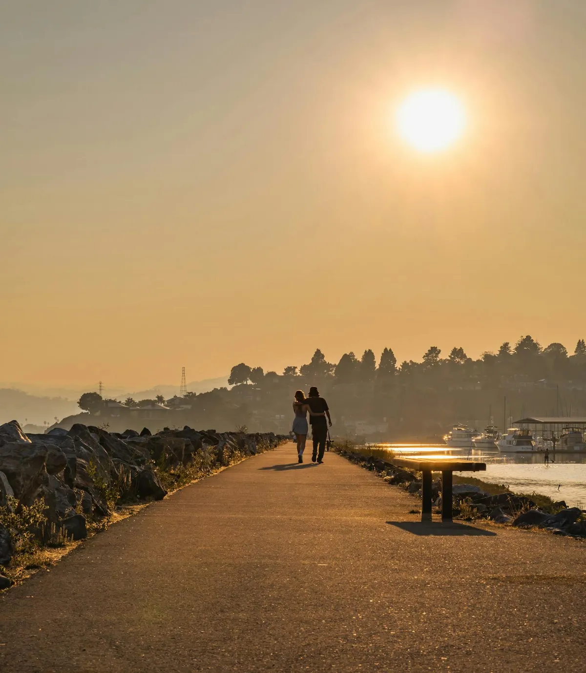A couple walking together toward a peaceful sunset