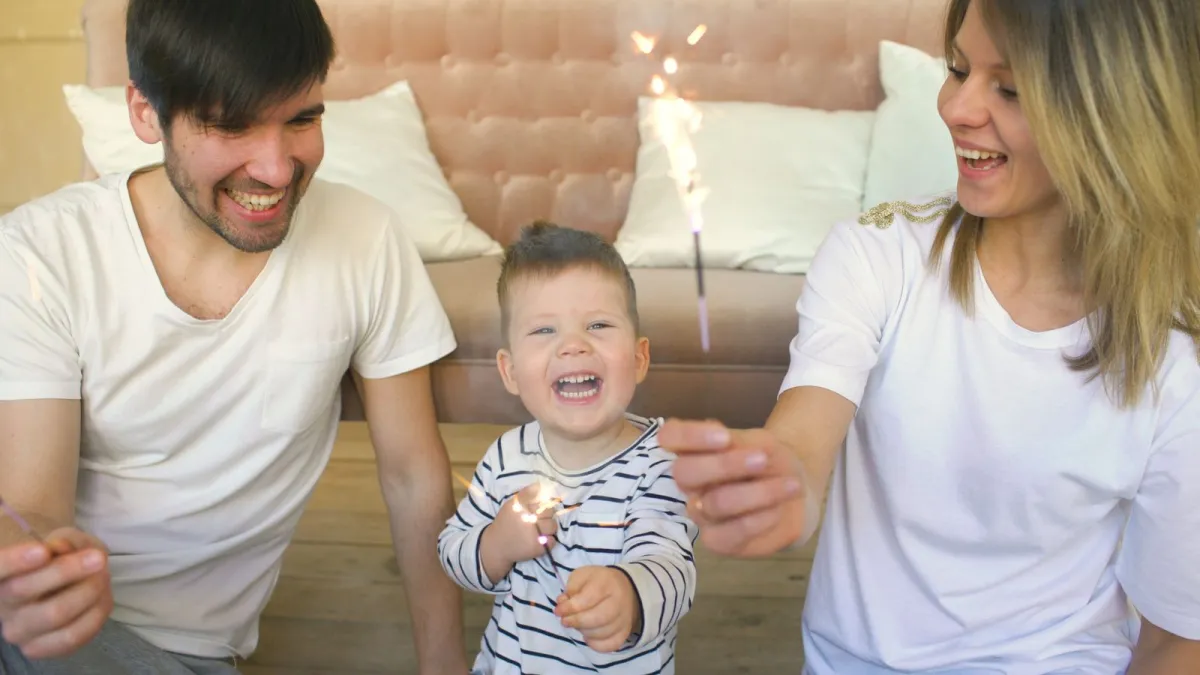 Happy parents holding their baby at home