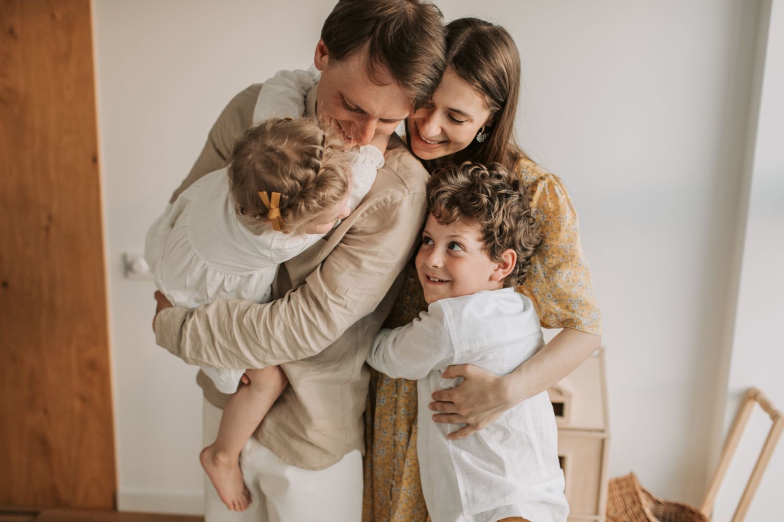 Parents hugging their children at home