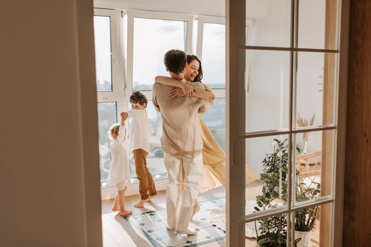 A happy family laughing together while cooking and baking in their bright home kitchen