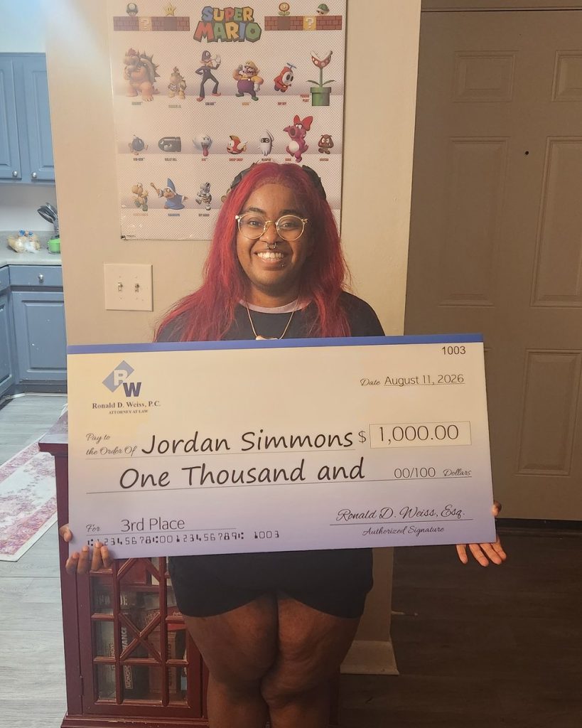 Jordan Simmons holding a large ceremonial check for $1,000 for winning third place in the Ronald D. Weiss, P.C. Spring 2026 scholarship essay contest, dated August 11, 2026.